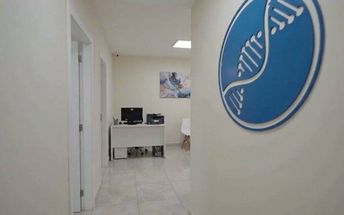 Corredor da LACEM, com o símbolo do DNA na parede e a estação de trabalho ao fundo